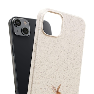 Biodegradable phone case with storybook rabbit design shown next to a smartphone, displaying fit and scale of the case.