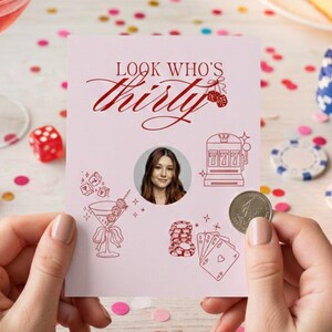 May include: A pink birthday card with the text "Look Who's Thirty" in red script, held by hands. The card features a photo, casino-themed illustrations, and a coin. A cocktail, dice, cake, and confetti are in the background.