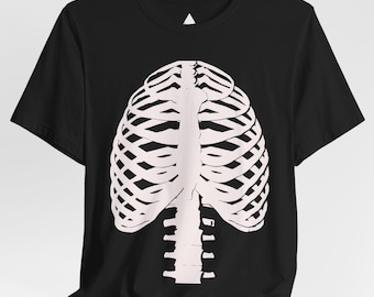 Puede incluir: Camiseta negra con una ilustración blanca de una caja torácica humana. El diseño de la caja torácica está centrado y es una representación anatómica detallada. La camiseta tiene mangas cortas y cuello redondo.