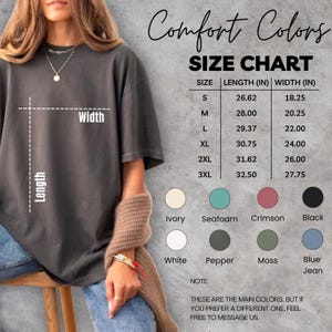 May include: A size chart for Comfort Colors t-shirts, with measurements in inches for sizes S through 3XL. The chart also displays color options including Ivory, Seafoam, Crimson, and Black. The text reads, "These are the main colors, but if you prefer a different one, feel free to message us."