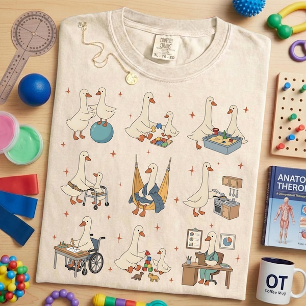 Può includere: T-shirt color crema con un design stravagante con oche dei cartoni animati in vari scenari di terapia occupazionale. La maglietta include il testo "COMFORT COLORS" e la taglia "XL 70-20". Gli strumenti di terapia occupazionale circondano la maglietta.