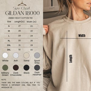 May include: A Gildan 18000 unisex heavy cotton crewneck sweatshirt in sand. The image includes a size chart with length and width measurements in inches for sizes S through 3XL, and a color palette showing white, ash, sand, sport grey, military green, dark chocolate, black, and dark heather options.