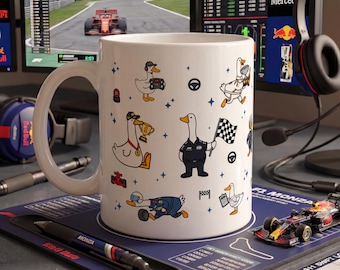 Könnte beinhalten: Ein weißer Keramikbecher mit einem wiederkehrenden Muster aus Zeichentrickenten in Rennsportkleidung, darunter Enten mit Trophäen, Zielflaggen und Lenkrädern, durchsetzt mit kleinen blauen Sternsymbolen und Rennsportmotiven.