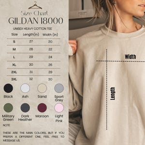 May include: A size chart for a Gildan 18000 unisex heavy cotton tee. The chart lists sizes S to 3XL with length and width measurements in inches. Color options include black, ash, sand, sport grey, military green, dark heather, maroon, and light pink.