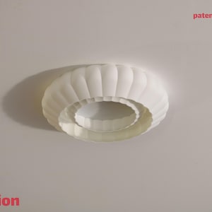 This is a white, 3d printed light shade that mounts onto 4 inch recessed lights. It diffuses the light beautifully, changing the harsh overhead light of recessed lighting into a soft glow, and provides a beautiful decorative touch as well. It has an elegant, scalloped edge and which has floral feeling to it. No hardware is needed to install the light, it comes with easy-to-install tabs that make install or changing a bulb simple.