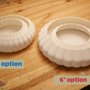 This is a white, 3d printed light shade that mounts onto 4 inch recessed lights. It diffuses the light beautifully, changing the harsh overhead light of recessed lighting into a soft glow, and provides a beautiful decorative touch as well. It has an elegant, scalloped edge and which has floral feeling to it. No hardware is needed to install the light, it comes with easy-to-install tabs that make install or changing a bulb simple.