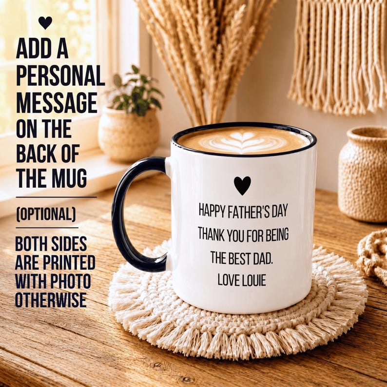 May include: A white ceramic mug with a black handle and rim, featuring a black heart icon and the text: Happy Father's Day, Thank you for being the best dad, Love Louie. The mug contains a latte with heart-shaped foam art on the surface.
