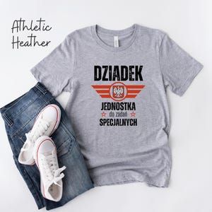 May include: A gray t-shirt with a black and red graphic design. The graphic features a Polish eagle with the text "Dziadek Jednostka do zadań specjalnych".