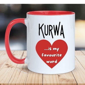 May include: White ceramic mug with a red rim and handle. The mug has a black graphic that says "KURWA...is my favourite word" with a red heart.