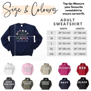 May include: A navy blue sweatshirt with the word "MAMA" and a floral design. The sweatshirt is available in sizes S-2XL and comes in a variety of colours, including white, light pink, sand, heliconia, red, dark heather, military green, forest green, navy, and black.