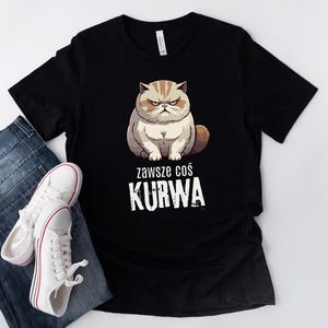 Może przedstawiać: Czarny T-shirt z kreskówkowym obrazkiem zrzędliwego kota i tekstem "Zawsze cos KURWA".