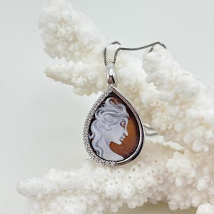 Pingente CAMEO gravado à mão em uma concha de Cassis Madagascariens em formato de gota, com engaste em prata 925 e zircônias.