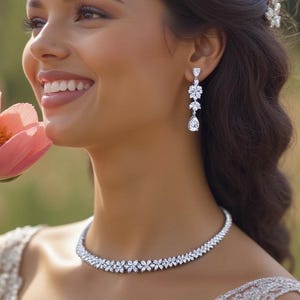 a stunning silver necklace with a leaf pattern and matching dangling earrings that feature three patterns leading to a teardrop