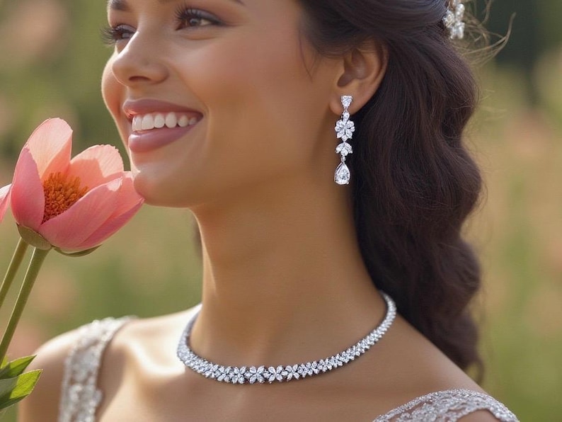 a stunning silver necklace with a leaf pattern and matching dangling earrings that feature three patterns leading to a teardrop