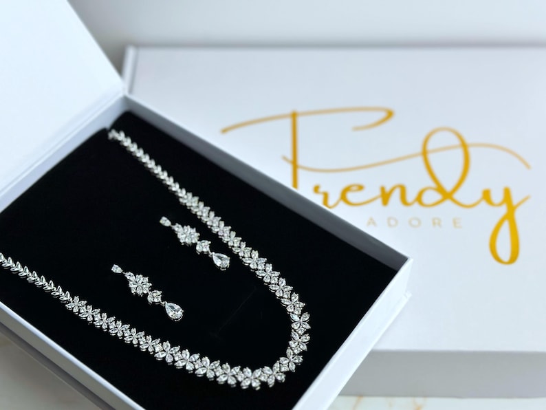 a stunning silver necklace with a leaf pattern and matching dangling earrings that feature three patterns leading to a teardrop