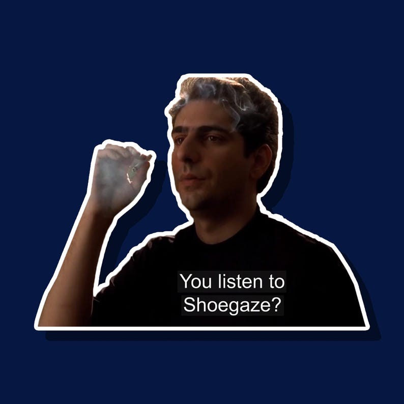 Puede incluir: Un hombre con cabello oscuro y una camisa negra mira a la c&aacute;mara y sostiene un cigarrillo. Est&aacute; exhalando humo. El texto "You listen to Shoegaze?" est&aacute; escrito debajo de &eacute;l.