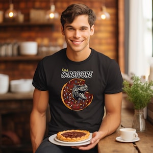 May include: A black t-shirt with a graphic of a dinosaur eating a donut. The text "I'm a CARBIVORE" is printed on the shirt.