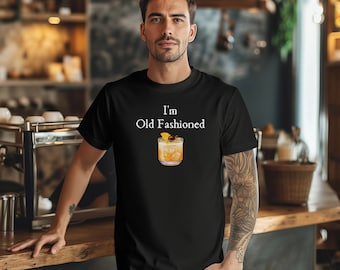 Puede incluir: Una camiseta negra con el texto "I'm Old Fashioned" y un gráfico de un cóctel old fashioned.