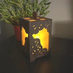 May include: A wooden lamp with a gear design on the front and sides. The lamp is lit and casting a warm glow.