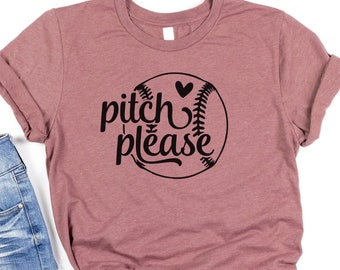 Op de afbeelding: Een mauve t-shirt met een zwarte baseball-afbeelding en de tekst "pitch please" met een hart boven de baseball.