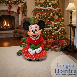 May include: Minnie Mouse in a red polka-dot dress with a green bow, green hat, and white gloves, posing in front of a decorated Christmas tree and fireplace. Presents are scattered around the tree. The text "Lengua Libertina A little bit of everything" is in the bottom right corner.