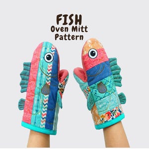 May include: Two quilted oven mitts shaped like fish, featuring colorful patchwork fabric in shades of blue, pink, orange, and teal. The mitts have embroidered eyes, fins, and scales. The text FISH Oven Mitt Pattern is printed above the mitts.