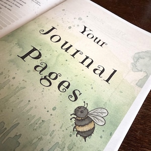 May include: A page from a journal featuring the black text Your Journal Pages printed in a decorative serif font. The background has a soft green watercolor wash with paint splatters and a small illustration of a fuzzy bumblebee.