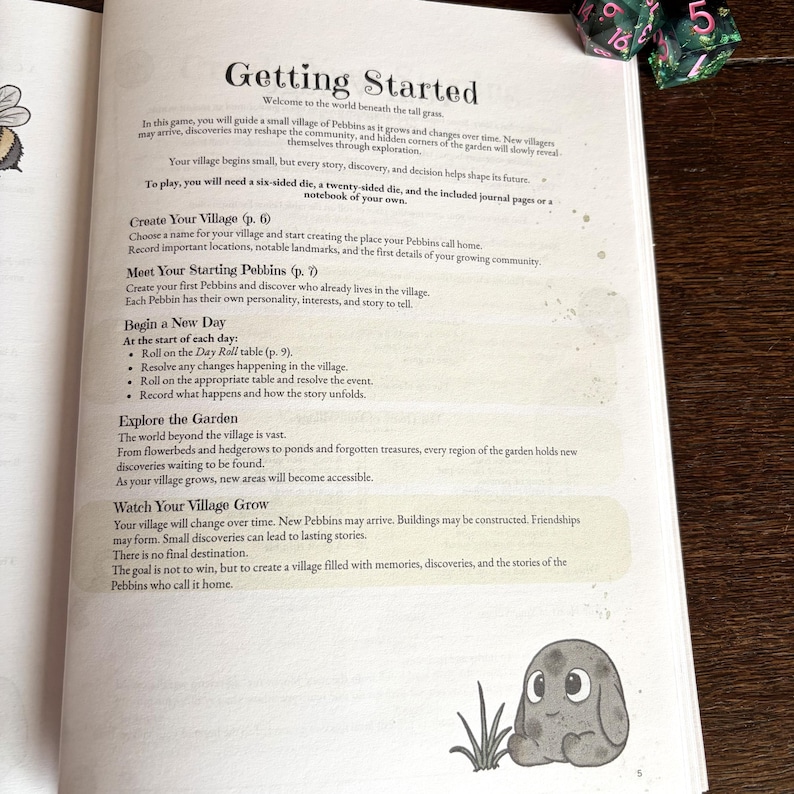 May include: A page from a game book titled Getting Started, featuring instructions for a village simulation game. The text outlines steps for creating a village, meeting characters, and exploring a garden. A small gray creature illustration sits at the bottom.