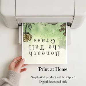May include: A white printer outputting a digital art print featuring a green watercolor background with a yellow dandelion, brown mushrooms, and the text Beneath the Tall Grass. The print includes the text Print at Home and Digital download only.