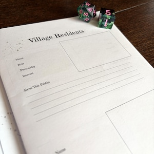 May include: A white paper character sheet titled Village Residents with fields for Name, Role, Personality, Interest, and About This Pebbin, accompanied by two translucent green polyhedral dice with pink numbers resting at the top of the page.