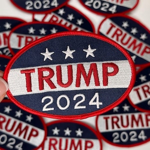 May include: A blue and red circular patch with white stars and the text "TRUMP 2024" in red and white lettering.