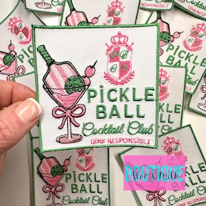May include: Green and pink embroidered iron-on patch with a cocktail glass, a pickle, and the text "Pickle Ball Cocktail Club Drink Responsibly".