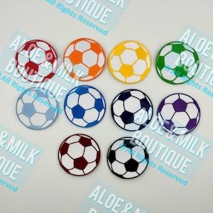 May include: Ten embroidered iron-on patches of soccer balls in various colors, including blue, red, yellow, orange, green, purple, and black.