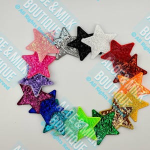 May include: A set of 14 star-shaped sequins patches in various colors, including pink, purple, blue, green, orange, red, and white. The sequins are arranged in a circle.