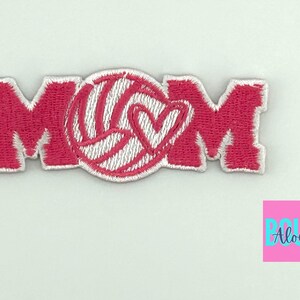 Pu&ograve; includere: Toppa in feltro rosa con la parola "MOM" in lettere bianche bordate. Una pallavolo bianca con un cuore rosa &egrave; al centro della toppa.
