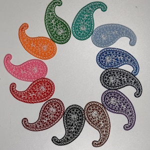May include: A set of 12 paisley-patterned iron-on patches in various colors, including orange, pink, red, black, brown, purple, blue, and green. The patches are all the same size and shape, and they have a white outline.