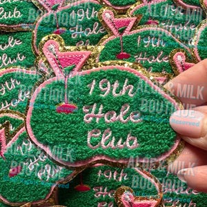 May include: Green and pink embroidered patch with gold glitter trim. The patch features a martini glass and the text "19th Hole Club".
