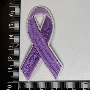 May include: Purple ribbon embroidered patch with white outline. The ribbon is tied in a knot and is approximately 2 inches in length.