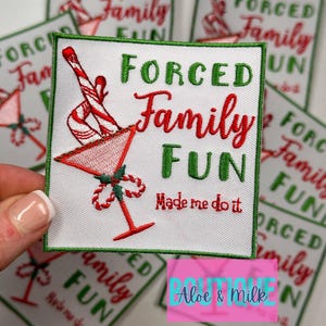 May include: White square patch with green border and the words "FORCED Family FUN" in red and green. A candy cane and martini glass are embroidered on the patch. The phrase "Made me do it" is also included.