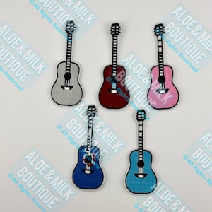 May include: Five embroidered iron-on patches of different colored acoustic guitars. The guitars are gray, red, pink, blue, and light blue.