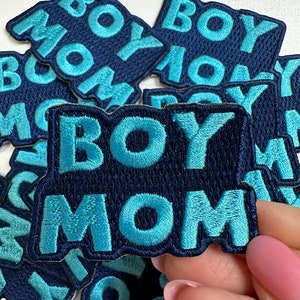 May include: A set of blue and teal embroidered iron-on patches that say "Boy Mom".