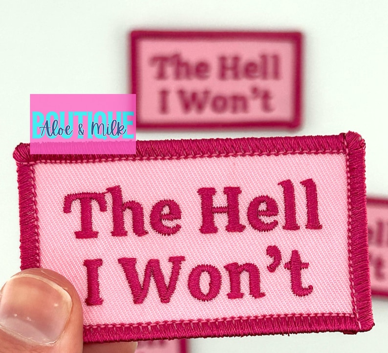May include: Pink fabric patch with pink stitching around the edges. The patch has the text "The Hell I Won't" in a bold, pink font.
