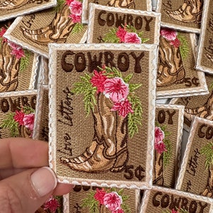 May include: A stack of embroidered iron-on patches featuring a cowboy boot with flowers and the text "Love Letters Cowboy 5¢".