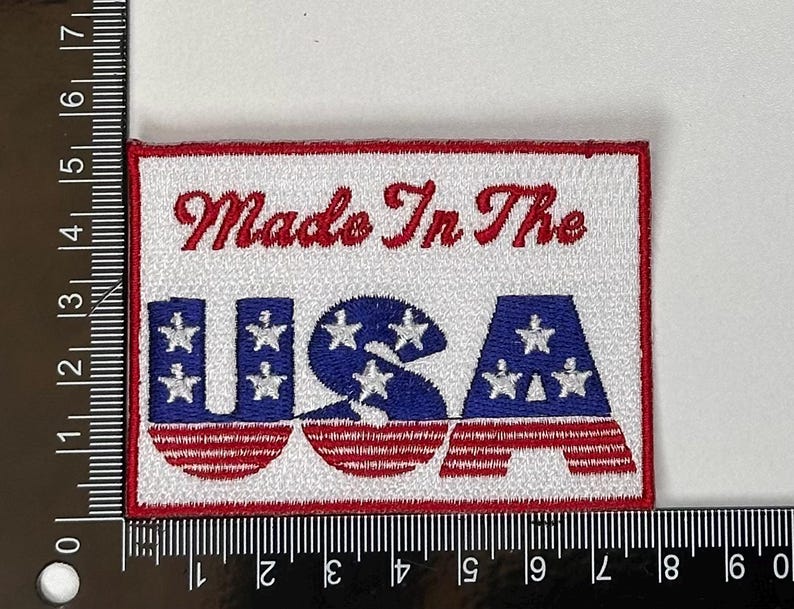 以下が含まれることがあります： 「Made In The USA」というテキストが書かれた、赤、白、青の刺繍パッチです。