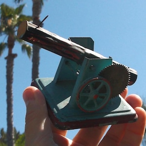 WWII-era mechanical tin toy see-saw log accessory for mini steam engine made in germany