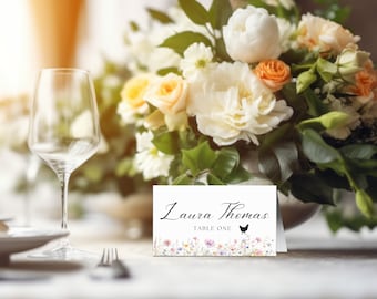 Peut inclure: Carte blanche avec du texte noir qui indique "Laura Thomas Table One" avec une silhouette noire de poulet. La carte a une bordure florale avec des fleurs roses, violettes et jaunes.
