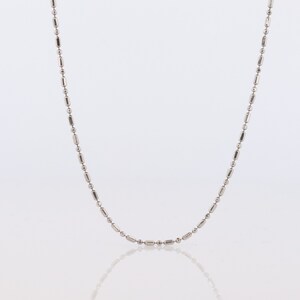 May include: A silver chain necklace with a delicate, rounded link design.