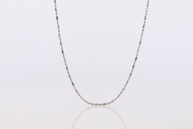 May include: A silver chain necklace with a delicate, rounded link design.
