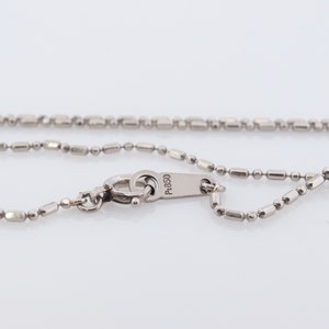 May include: A silver chain necklace with a lobster clasp and a tag that reads "P-950".