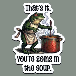 May include: A sticker featuring a green frog wearing an apron, stirring a pot of soup. The text "That's it. You're going in the soup" is displayed in a white font.